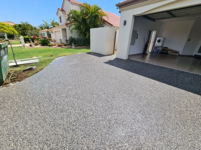 Residential driveway with a smooth aggregate concrete finish leading to a modern home