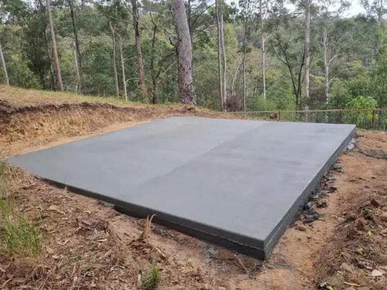 Freshly laid concrete foundation by A1 Concreting in a serene forest setting